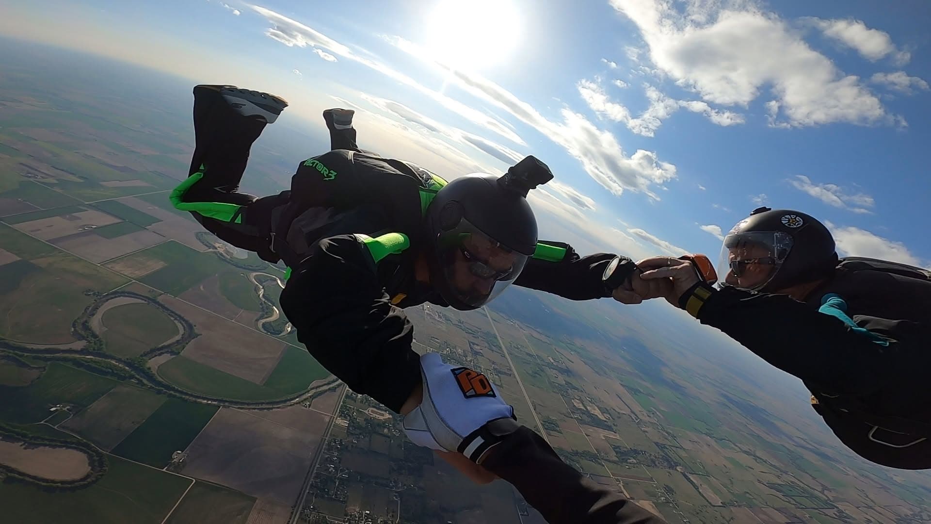 Two Skydive K-State jumpers linking up in freefall above the fields around Abilene, Kansas